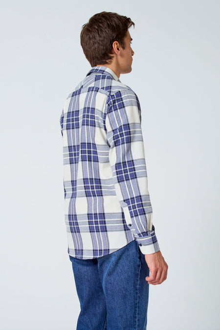 T-shirt multicolore à manches longues de Le Fabuleux Marcel de Bruxelles, avec un motif à carreaux, porté avec des jeans bleus foncés.