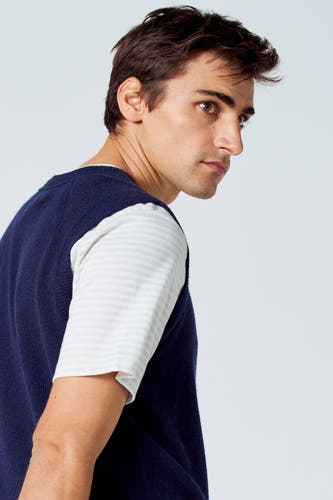 T-shirt bleu de Le Fabuleux Marcel de Bruxelles, porté sur un chemisier rayé, en photo rapprochée de côté.