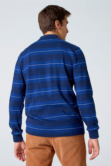 Polo bleu à longues manches de Le Fabuleux Marcel de Bruxelles, rayé de blancs, sur un pantalon corduroy marron.