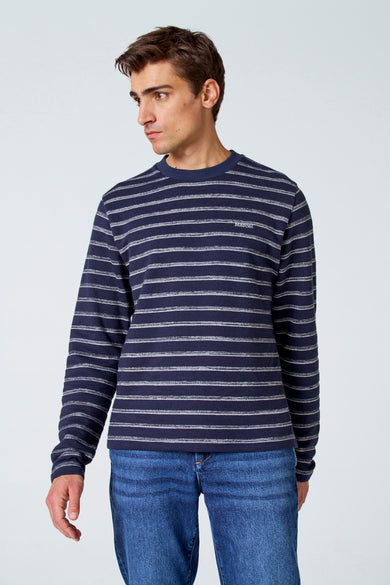 T-shirt rayé blanc avec longues manches de Le Fabuleux Marcel de Bruxelles, porté avec un jean bleu.