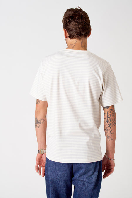 Grijs T-shirt met korte mouwen van Le Fabuleux Marcel de Bruxelles, met een gestreept patroon en gedragen met jeans en een horloge.
