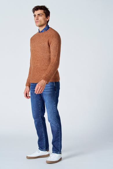 Veste brune avec col rond de Le Fabuleux Marcel de Bruxelles, portée avec un chemisier rayé bleu et des jeans bleus, vue latérale.