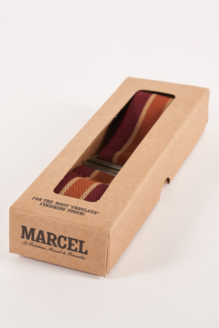 Laisse multicolore de Le Fabuleux Marcel de Bruxelles dans une boîte en carton à rayures.
