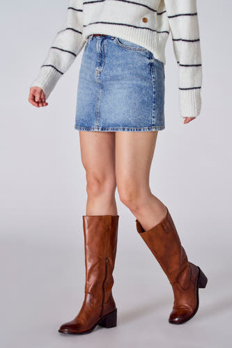 Korte lichtblauwe denim rok van Le Fabuleux Marcel de Bruxelles, met een wit gestreepte trui en bruine laarzen.
