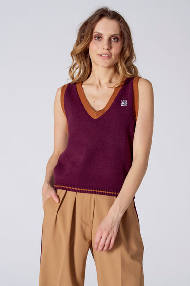 Débardeur bordeaux avec col en V et bordure marron, de Le Fabuleux Marcel de Bruxelles, avec petit logo blanc sur la poitrine, tricoté, exemple de style de vie