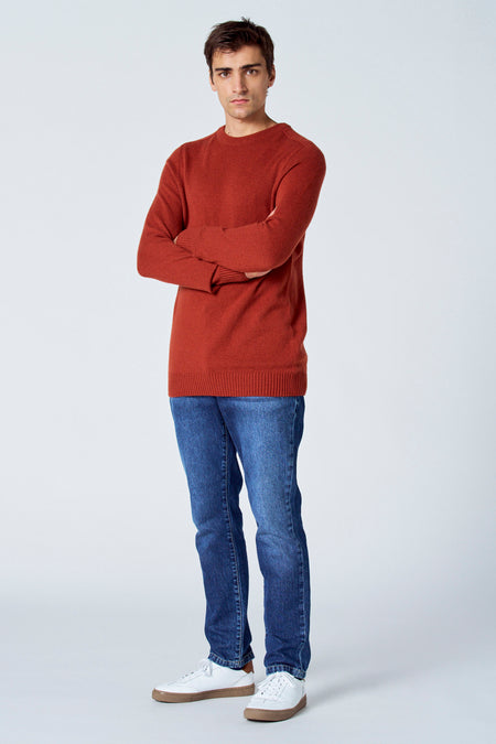 Veste de Bordeaux avec col rond du Le Fabuleux Marcel de Bruxelles, associée à des jeans et des baskets blanches.