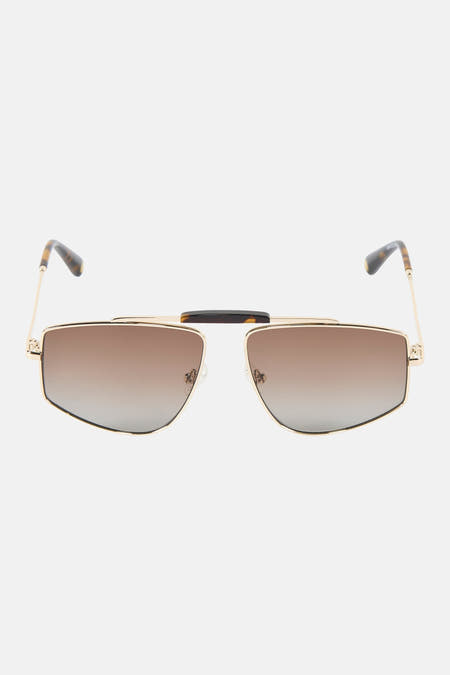 Lunettes de soleil dorées de Le Fabuleux Marcel de Bruxelles avec verres marron, à côté d'un étui en cuir bleu enroulé avec le nom 'MARCEL' estampé à l'intérieur.