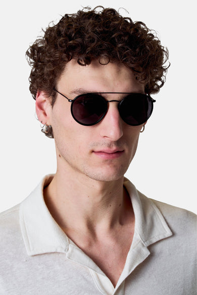Lunettes de soleil multicolores de Le Fabuleux Marcel de Bruxelles, avec des montures noires et portées par un modèle.
