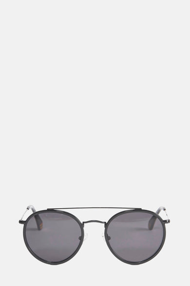 Lunettes de soleil noires de Le Fabuleux Marcel de Bruxelles, avec un cadre rond et une fine bride supérieure.