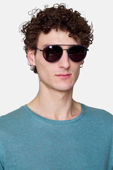 Lunettes de soleil bleues de Le Fabuleux Marcel de Bruxelles, avec un cadre fin et un t-shirt bleu-vert.