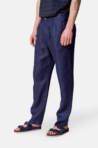 Pantalon de costume bleu Le Le Fabuxux Marcel de Bruxelles, avec des plis à l'avant et porté avec des sandales bleues.