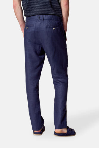 Pantalon de costume bleu Le Fabuleux Marcel de Bruxelles, vu de derrière, avec des poches à boutons et des pantoufles bleu marine.