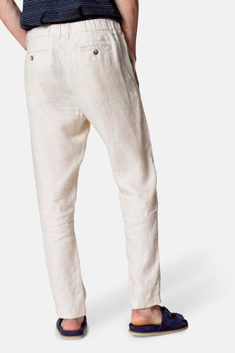Pantalon de costume beige Le Le Fabux Marcel de Br Brelles, avec des poches arrière et porté avec des sandales bleues.
