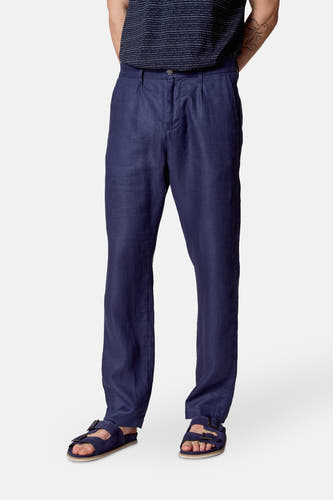 Pantalon de costume bleu Le Le Fabuxux Marcel de Bruxelles, avec des plis et un modèle décontracté, porté avec des sandales.