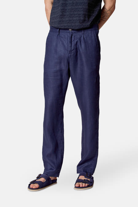 Pantalon de costume bleu Le Le Fabuxux Marcel de Bruxelles, avec des plis et un modèle décontracté, porté avec des sandales.