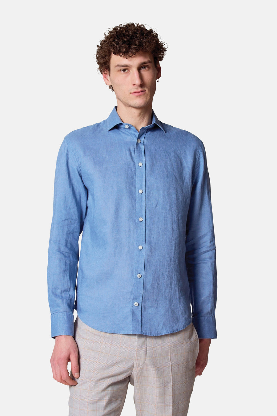 Man in blauw linnen overhemd en geruite broek.