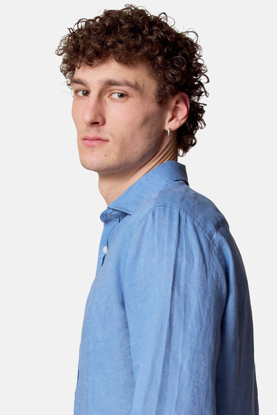 Man in blauw linnen overhemd, zijwaarts kijkend.