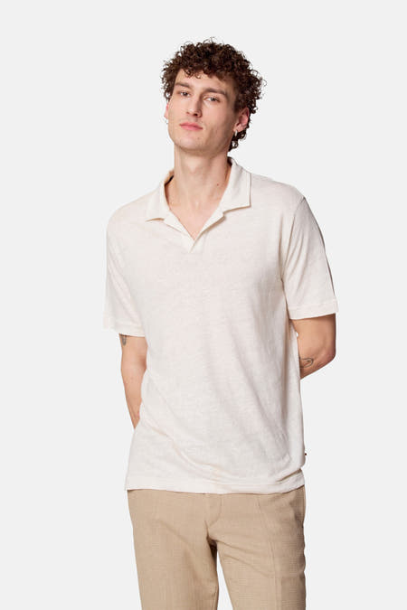 Polo beige à manches courtes de Le Fabuleux Marcel de Bruxelles, porté avec un pantalon kaki.