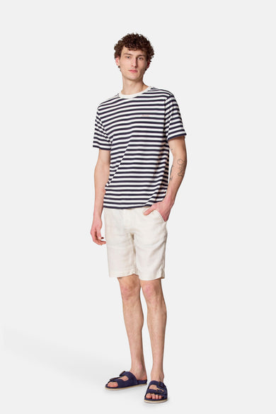 T-shirt bleu à manches courtes de Le Fabuleux Marcel de Bruxelles, rayé et porté avec un pantalon beige.