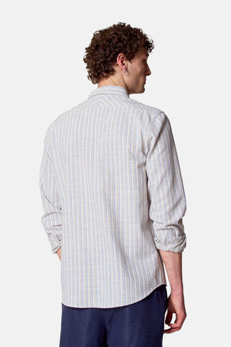 Chemise rayée à manches longues multicolore de Le Fabuleux Marcel de Bruxelles, vue de derrière, avec des manches retroussées et un pantalon foncé.