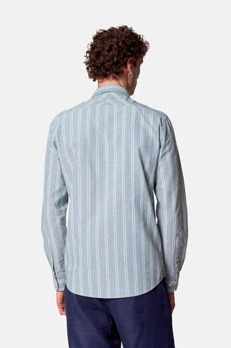 Chemise rayée verte à longues manches de Le Fabuleux Marcel de Bruxelles, vue de derrière, associée à un pantalon bleu marine.