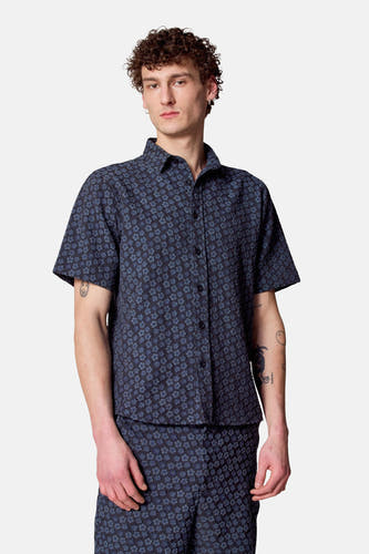 Chemise bleue à manches courtes de Le Fabuleux Marcel de Bruxelles, avec motif floral et tissu texturé.