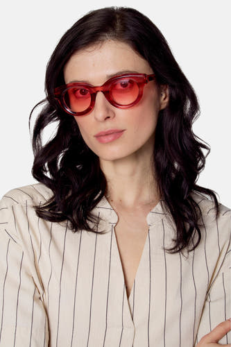 Lunettes de soleil roses de Le Fabuleux Marcel de Bruxelles, portées avec une chemise à carreaux en V.