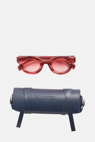 Lunettes de soleil roses de Le Fabuleux Marcel de Bruxelles, avec un étui à lunettes bleu en dessous.
