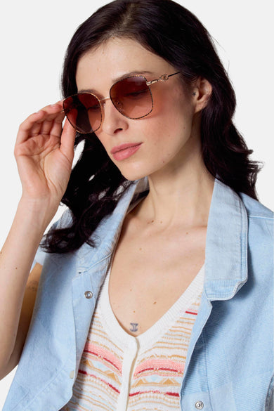 Lunettes de soleil roses de Le Fabuleux Marcel de Bruxelles, avec un cadre doré et des accents tortue sur les branches.
