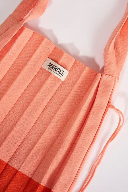 Manteau épaules orange de Le Fabuleux Marcel de Bruxelles, avec texture plissée et une étiquette.
