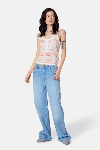 T-shirt multicolore de Le Fabuleux Marcel de Bruxelles, avec des rayures horizontales et porté avec des jeans larges.