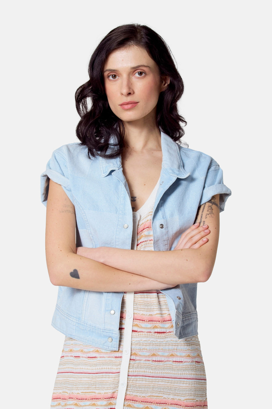 Lichtblauwe jeansjas van Le Fabuleux Marcel de Bruxelles, met korte mouwen en gedragen over een gestreept jurkje.
