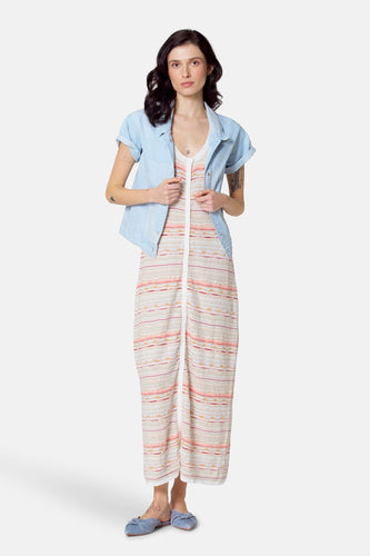 Lichtblauwe jeansjas van Le Fabuleux Marcel de Bruxelles, met korte mouwen en een geknoopte sluiting, gecombineerd met een gestreepte jumpsuit.
