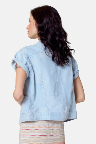 Lichtblauwe jeansjas van Le Fabuleux Marcel de Bruxelles, met korte mouwen en een rok met gestreept patroon.
