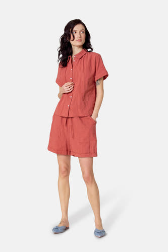 Short rouge de Le Fabuleux Marcel de Bruxelles avec des rayures blanches, vu de derrière, avec des chaussons bleus.