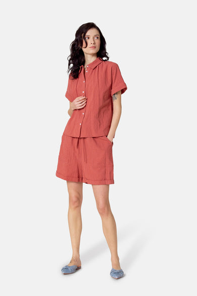 Short rouge de Le Fabuleux Marcel de Bruxelles avec des rayures blanches, vu de derrière, avec des chaussons bleus.