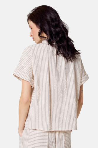 Chemise beige à manches courtes de Le Fabuleux Marcel de Bruxelles, avec des rayures verticales subtiles.