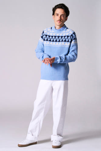 T-shirt bleu avec col rond de Le Fabuleux Marcel de Bruxelles, avec un motif géométrique sur les épaules, associé à une pantalon blanc et des baskets.