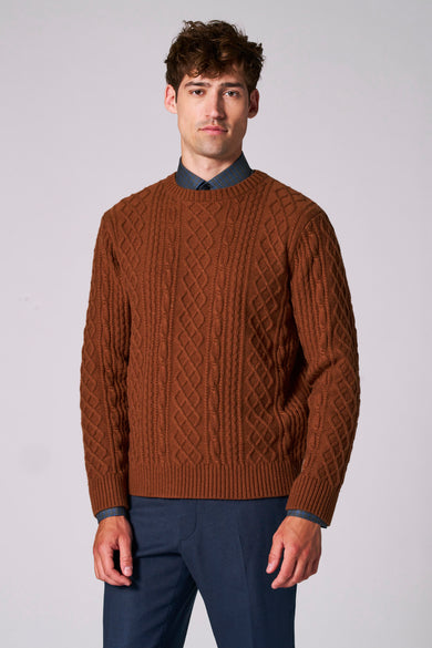Pull marron avec col rond de Le Fabuleux Marcel de Bruxelles, avec un motif côtelé sur le dos, porté avec une chemise bleue à carreaux.