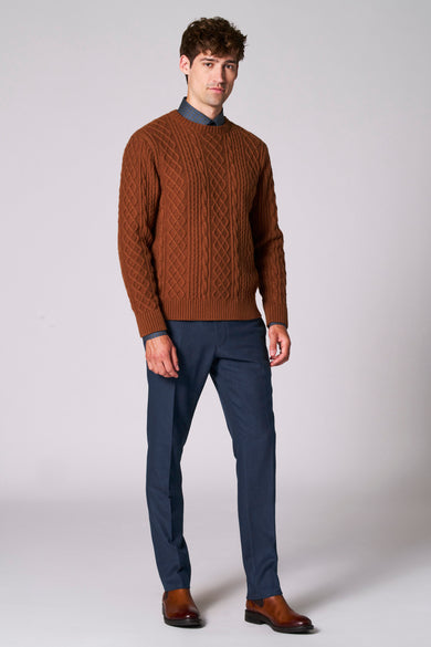 Pull marron avec col rond de Le Fabuleux Marcel de Bruxelles, à motif côtelé, associé à un pantalon bleu et des chaussures en cuir marron.
