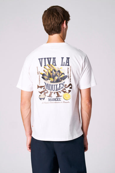 T-shirt blanc à manches courtes de Le Fabuleux Marcel de Bruxelles, porté avec un pantalon bleu marine.