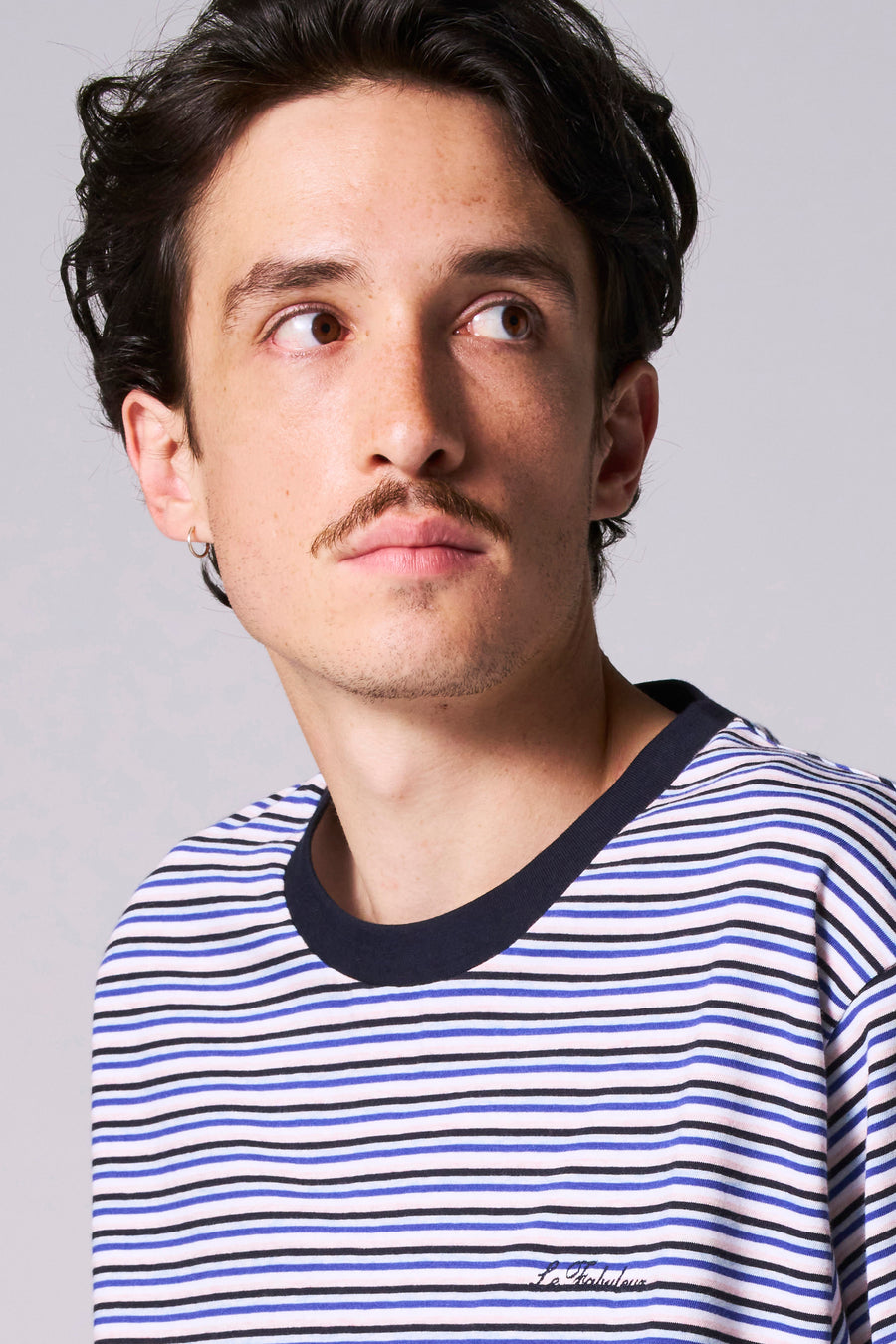 Man in gestreepte trui met korte mouwen.