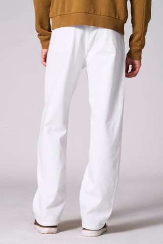Jean blancs off-white de Le Fabuleux Marcel de Bruxelles, avec des chaussures marrons et un pull marron.
