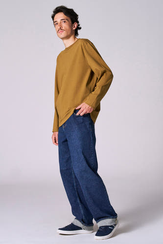 T-shirt beige à longues manches de Le Fabuleux Marcel de Bruxelles, avec des jeans bleu marine et des sneakers bleu marine.