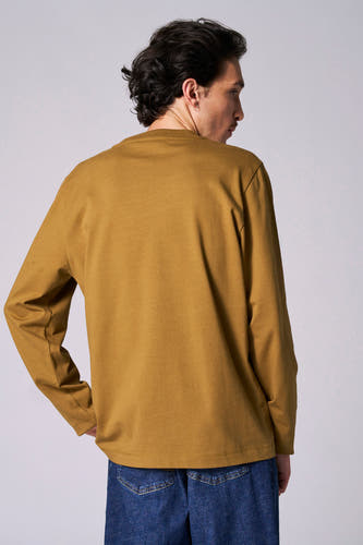 T-shirt beige à longues manches de Le Fabuleux Marcel de Bruxelles, vu de derrière, associé à un jean bleu.