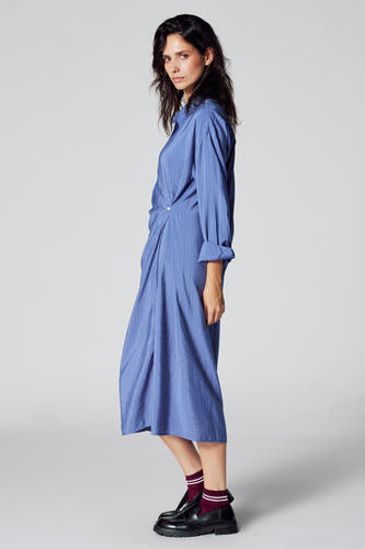 Tunique bleue à longues manches de Le Fabuleux Marcel de Bruxelles, avec des rayures verticales et des détails boutonnés.