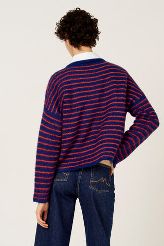 Pull multicolore à col rond de Le Fabuleux Marcel de Bruxelles, avec des rayures horizontales et porté avec un jean foncé.