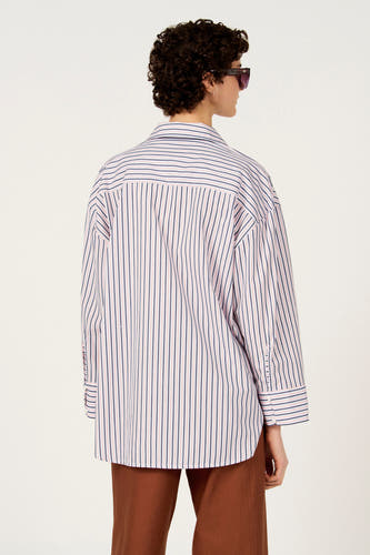 Chemise multicolore à manches longues de Le Fabuleux Marcel de Bruxelles, avec rayures verticales et pantalon marron.