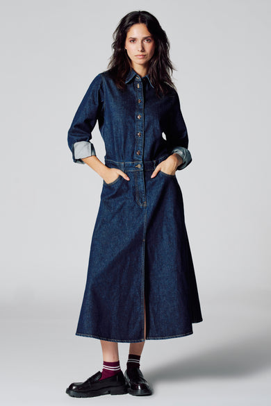 Jupe en denim bleu marine à longues manches de Le Fabuleux Marcel de Bruxelles, avec fermeture à boutons et poches.