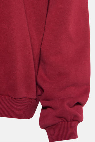 Gilet rouge de Le Fabuleux Marcel de Bruxelles, avec des manches longues et des cols côtelés, gros plan.